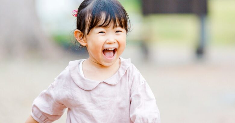 子どもが笑顔で走っている画像